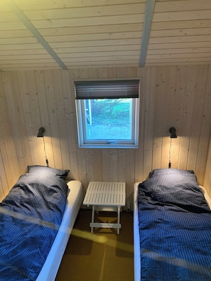 A small cabin with two beds, a window with a view, and a small table. - Scenic house on East Funen 200m from the Belt (Frørup)