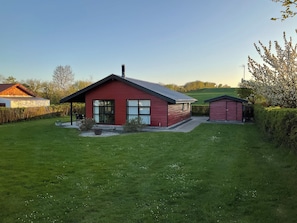 Ein rotes Haus mit einem großen Fenster und einer Garage.