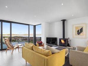 Una sala moderna con un ventanal grande, una chimenea y un televisor.
