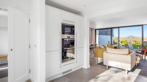 A modern kitchen with built-in appliances and a dining area with a view.