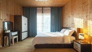 Un dormitorio con cama, mesita de noche, lámpara, armario y escritorio con espejo.