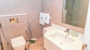 Un bagno moderno con WC, lavandino e zona doccia.
