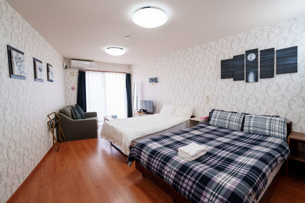 Ett hotellrum med en säng, en soffa, ett skrivbord och ett konstverk som hänger på väggen.