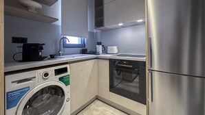 Une cuisine compacte équipée d’un lave-linge, d’un réfrigérateur et d’un lave-vaisselle.