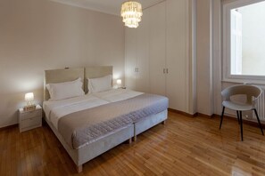 A bedroom with a bed, nightstands, a chair, and a window.