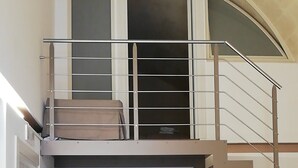 Un interior modern amb una escala que mena a un dormitori tipus loft.