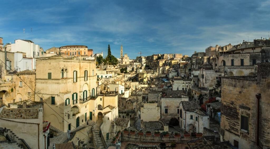 A densely packed urban area with historic buildings, narrow streets, and a prominent tower in the distance.