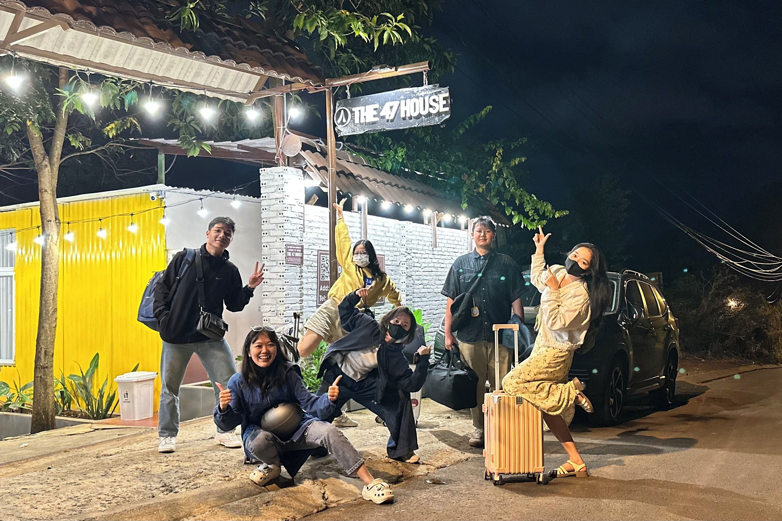 Un grup de persones davant d'un edifici amb un rètol que diu “THE 47 HOUSE”.