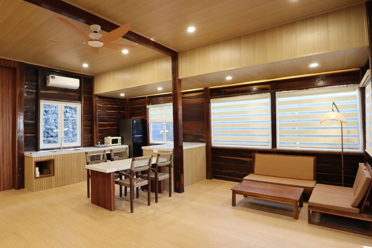 Una cocina moderna con una isla central, paneles de madera y un ventilador de techo.