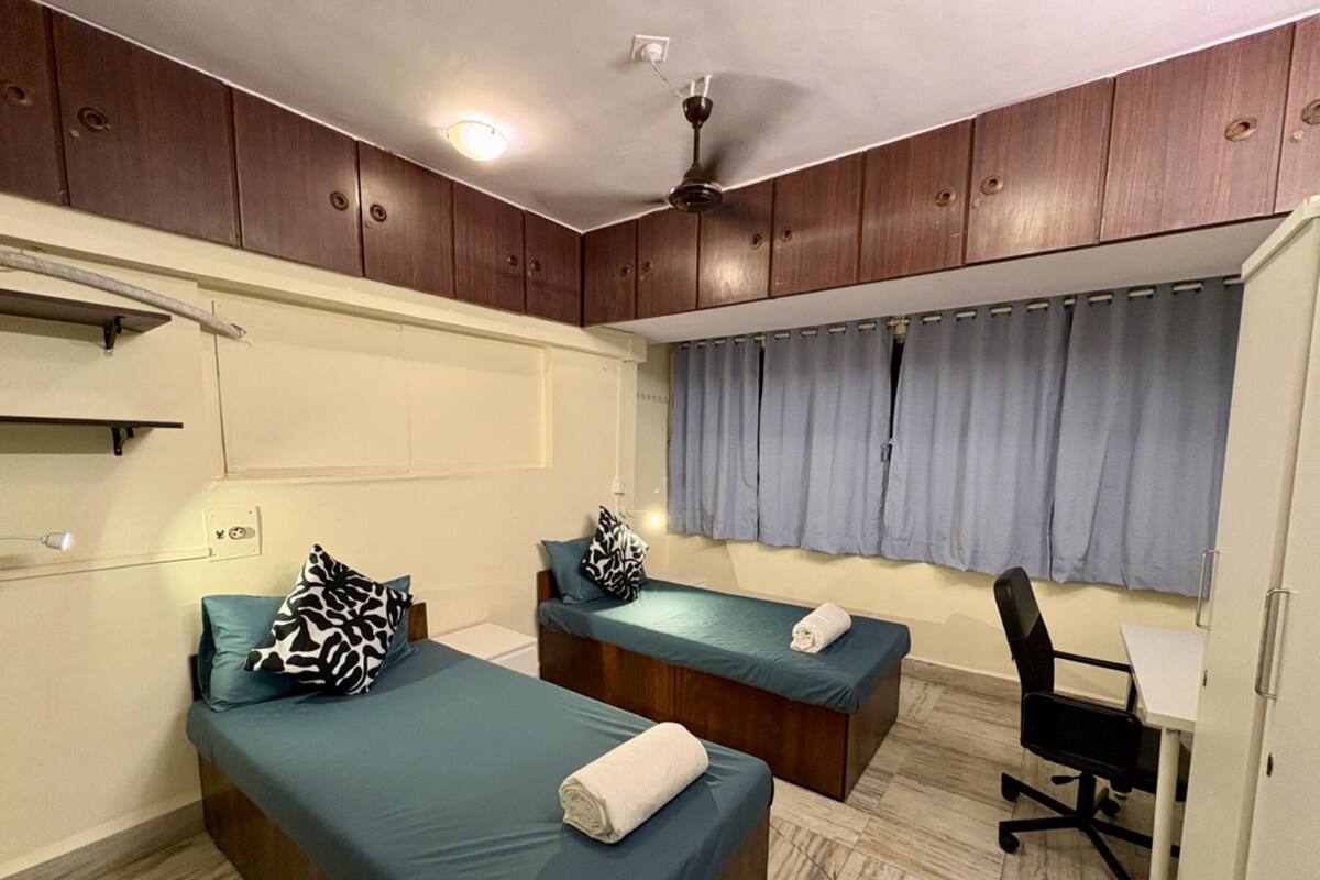Une chambre avec deux lits, un bureau et une chaise.