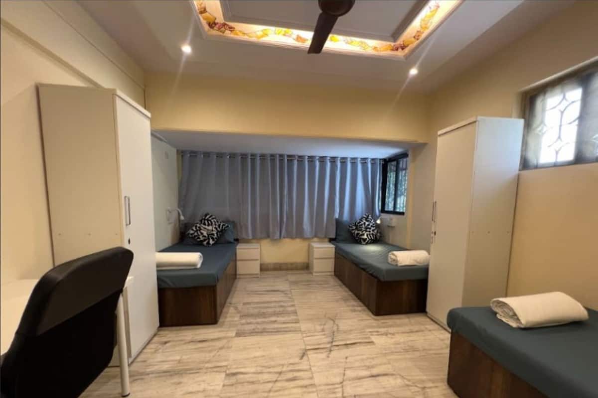Une chambre avec deux lits, un bureau et une chaise.