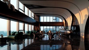 A spacious lobby with a high ceiling, large windows, and a reflective floor. - Maiyue Hotel-Chongqing Jiefangbei (Chongqing)