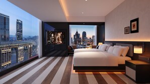A modern hotel room with a large bed, a city view, and a television displaying a show. - Maiyue Hotel-Chongqing Jiefangbei (Chongqing)