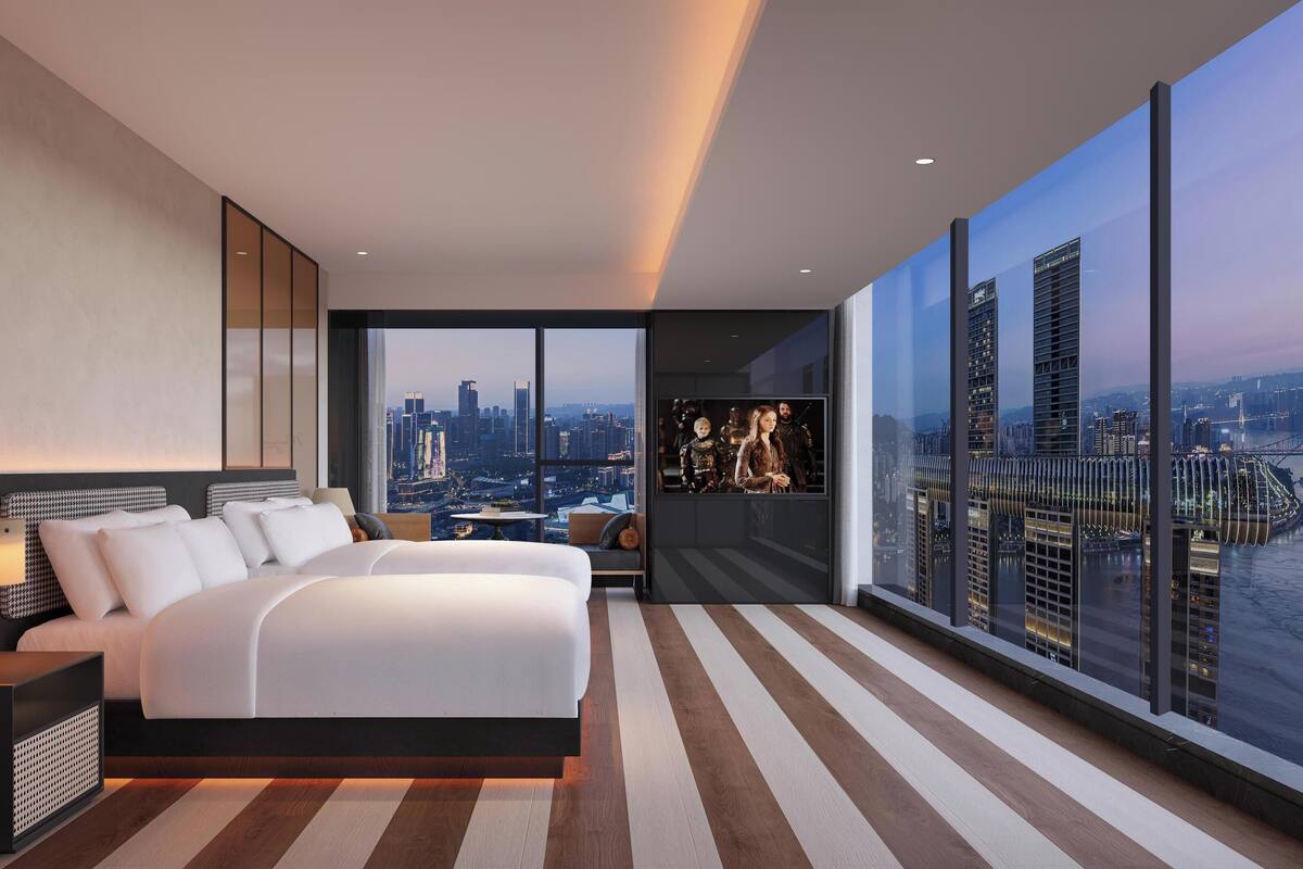 Ein modernes Schlafzimmer mit einem großen Bett, Nachttischen und Blick auf die Stadt.