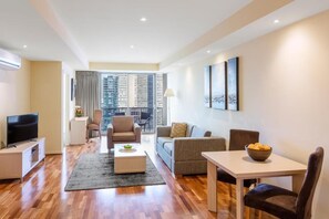 Relax in a spacious living room with a city view, flat-screen TV, and dining area.