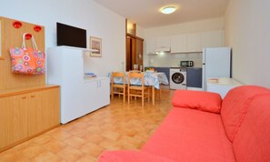 A compact living space with a kitchenette, a dining area, and a sofa. - Stylish house with a lovely terrace (Bibione)