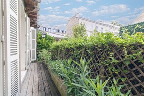 Guests can enjoy a garden area from a narrow deck with a wooden lattice fence.