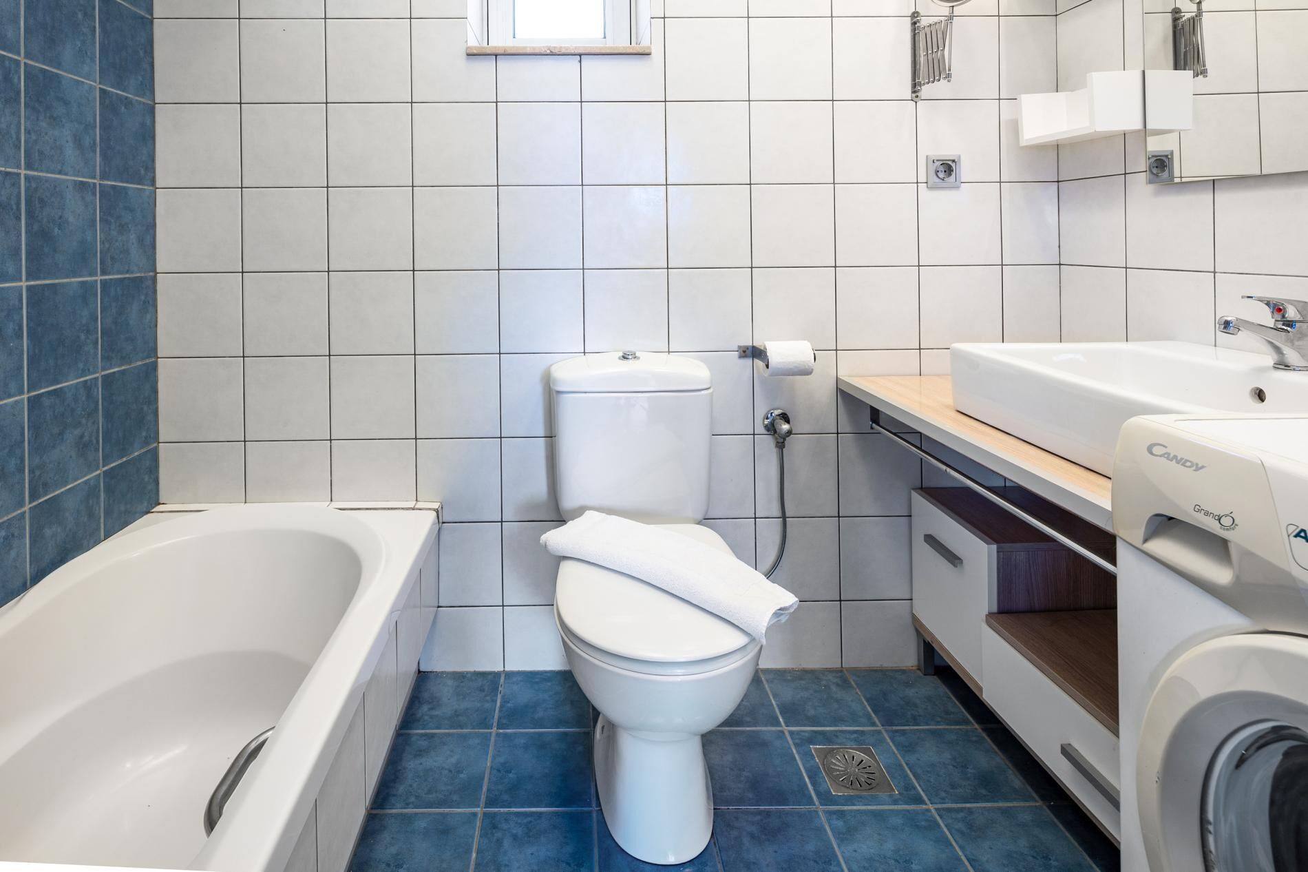 Une salle de bain moderne équipée d’une baignoire, de toilettes et d’un lave-linge.