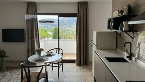 A modern kitchen with a built-in microwave, a sink, and a dining area with a table and chairs. - CASA YANGUAS APARTAMENTOS RURALES (Laujar de Andarax)