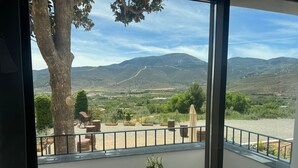 A balcony with a view of a mountainous landscape, a tree, and outdoor furniture. - CASA YANGUAS APARTAMENTOS RURALES (Laujar de Andarax)