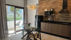 A modern kitchen with a brick backsplash, a built-in microwave, and a stainless steel refrigerator. - CASA YANGUAS APARTAMENTOS RURALES (Laujar de Andarax)