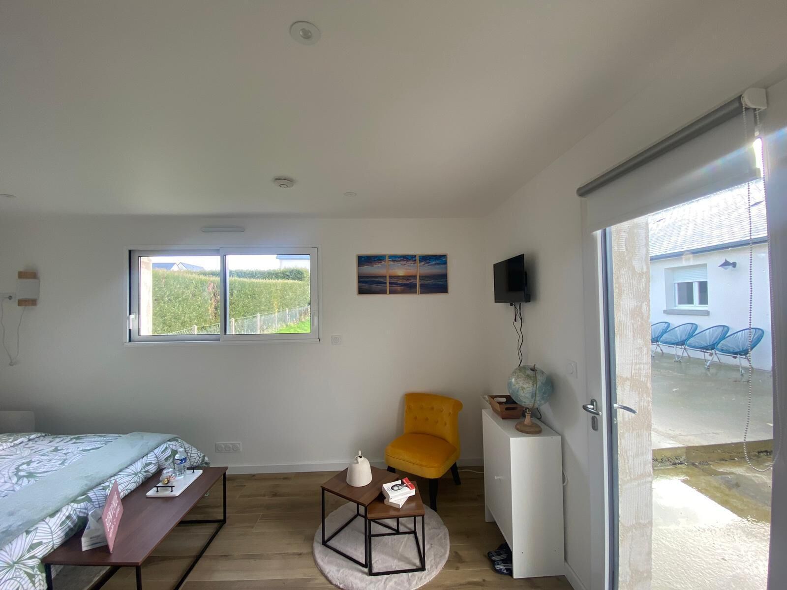 Quarto com cama, escrivaninha, cadeira, globo e televisão.