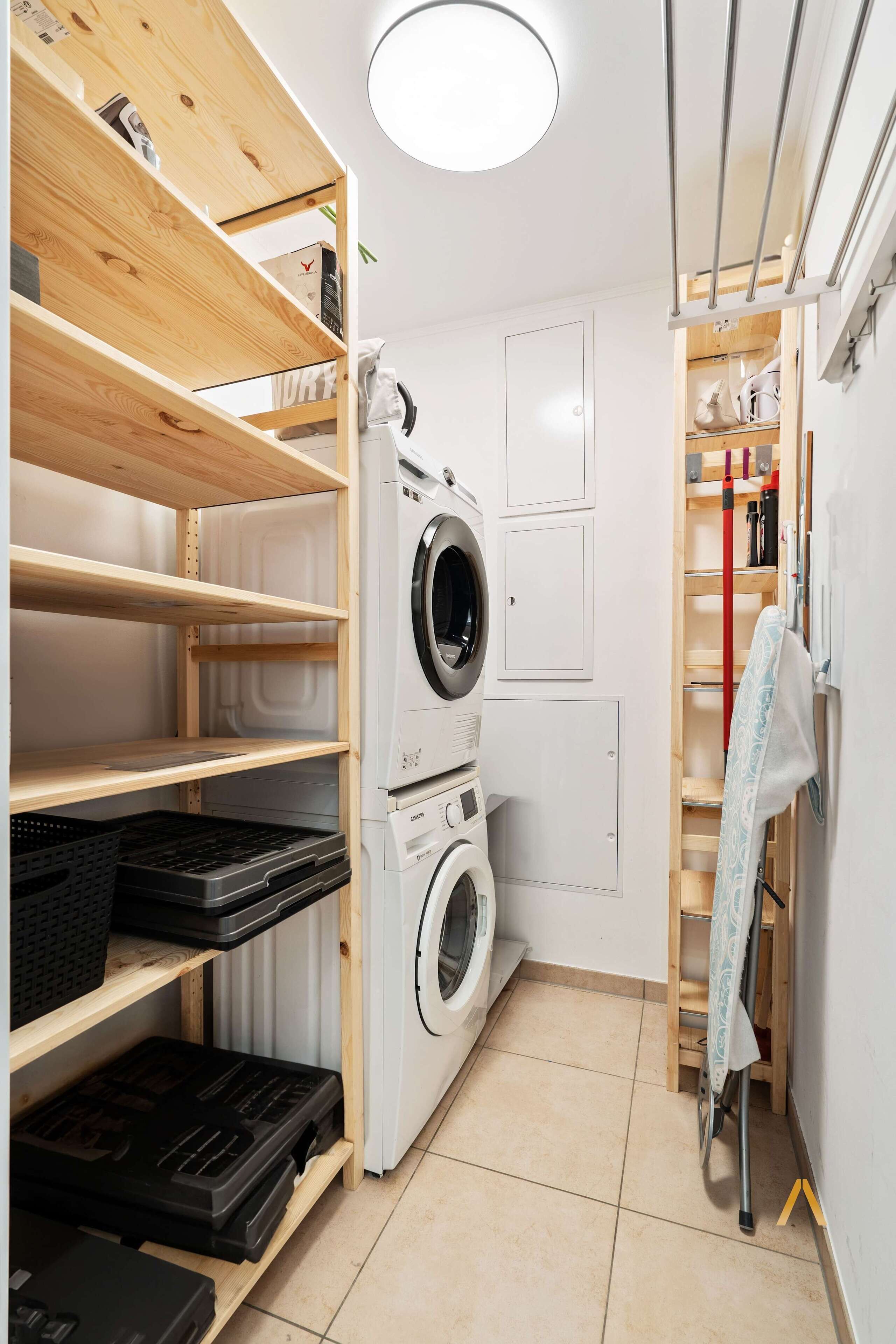 Convenient laundry room equipped with a washer. Ample shelving and storage space to keep your laundry essentials organized.