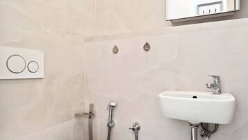 Un baño moderno con inodoro, lavamanos y ducha.
