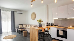 Una cocina moderna con una isla de madera, taburetes de bar y un horno empotrado.