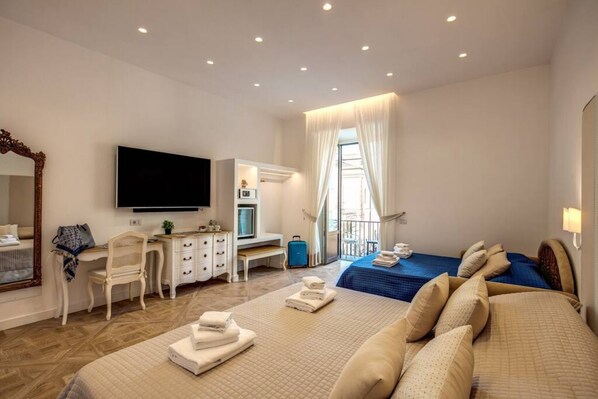 Una habitación de hotel con una cama, un escritorio, un televisor y una ventana con cortinas.