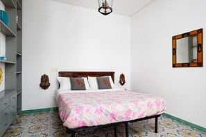 A bedroom with a bed, a dresser, a mirror, and a chandelier. - Casa Sofia | 3 Bedrooms, 3 Bathrooms & Sea View (Sorrento)