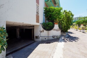 A building with a garage entrance, a concrete planter with greenery, and a clear sky. - Casa Sofia | 3 Bedrooms, 3 Bathrooms & Sea View (Sorrento)