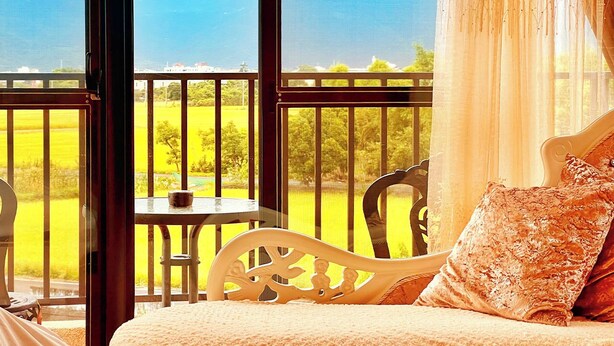 Une chambre avec un balcon, un lit et une table.