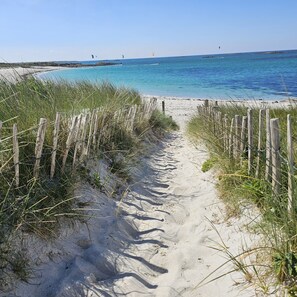 A sandy beach path leading to the ocean, with wooden fences on either side. - Charming house with stunning sea views and direct beach access (Plouguerneau)