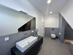 Een haardroger, handdoeken, zeep, toiletpapier