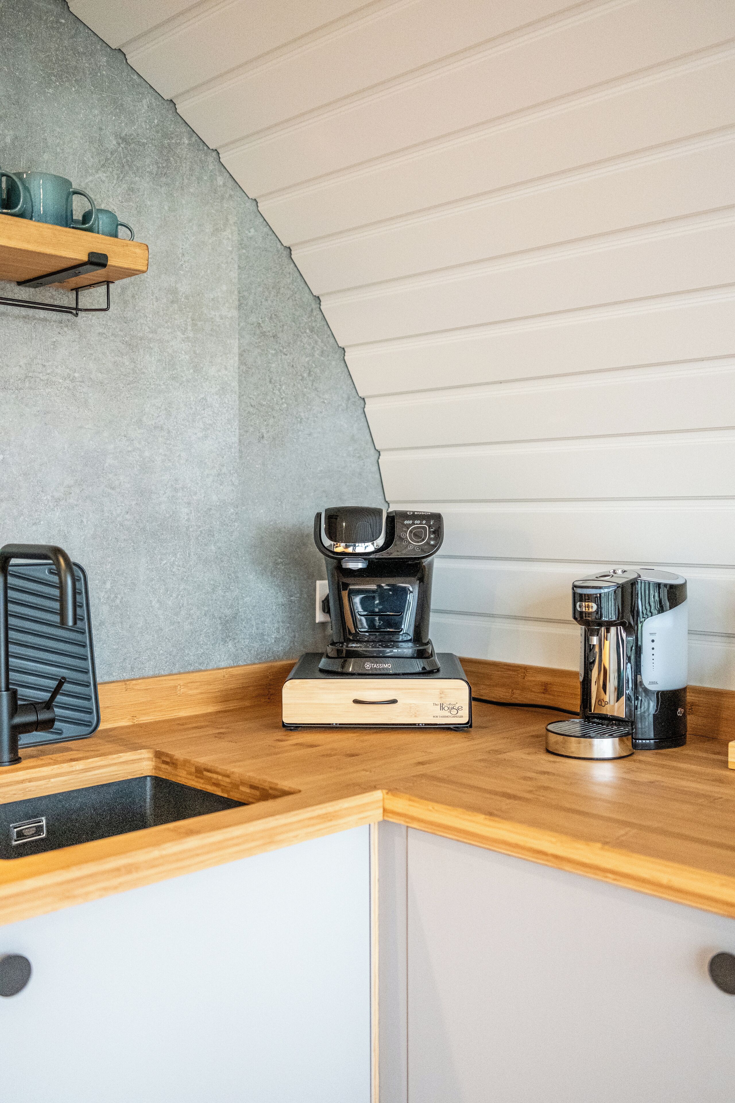 A kitchenette with a coffee maker, a toaster, and a sink.