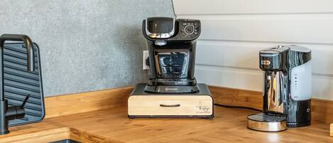 A kitchenette with a coffee maker, a toaster, and a sink.