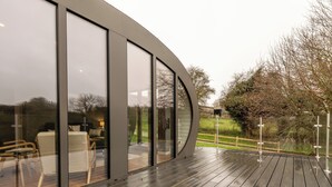 Un edificio moderno con ampie vetrate e un terrazza in legno.