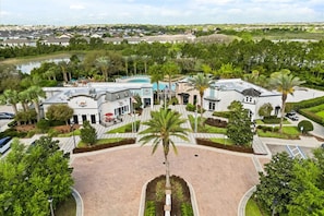 Un resort con piscina, palmeras y vistas del entorno.