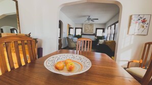 Un coin repas avec une table en bois, des chaises et une assiette de pommes.