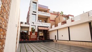 Un hôtel appelé «Hotel Sheel Gopal», doté d’une architecture moderne, avec une cour intérieure centrale, un sol à motifs et un escalier menant à l’entrée.
