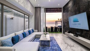 Una sala de estar moderna con un sofá, una mesa de centro y una televisión mostrando 'ADREAM VILLAS'.