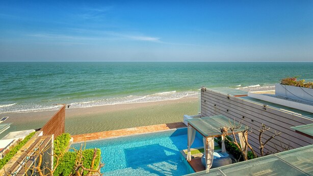 Una piscina con vista a la playa y al océano.