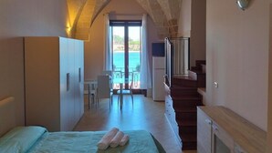 A bedroom with a bed, a desk, and a view of the sea. - Verso Oriente  (Brindisi)
