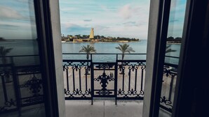 A balcony with a view of a coastal area, including a lighthouse and palm trees. - Verso Oriente  (Brindisi)