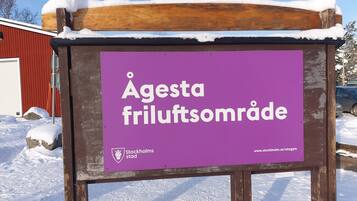A sign for Agesta Friluftssområde with a website URL.
