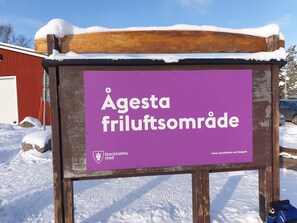 En skylt för Agesta friluftsområde med en webbadress.