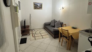 A compact living space with a sofa, a dining table, and a kitchen area. - Close to Paris and Disney, Self-contained apartment (Le Perreux-sur-Marne)