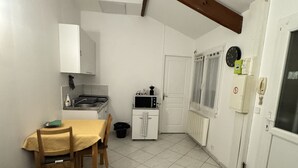 A compact kitchen with a dining area, a sofa, and a tiled floor. - Close to Paris and Disney, Self-contained apartment (Le Perreux-sur-Marne)