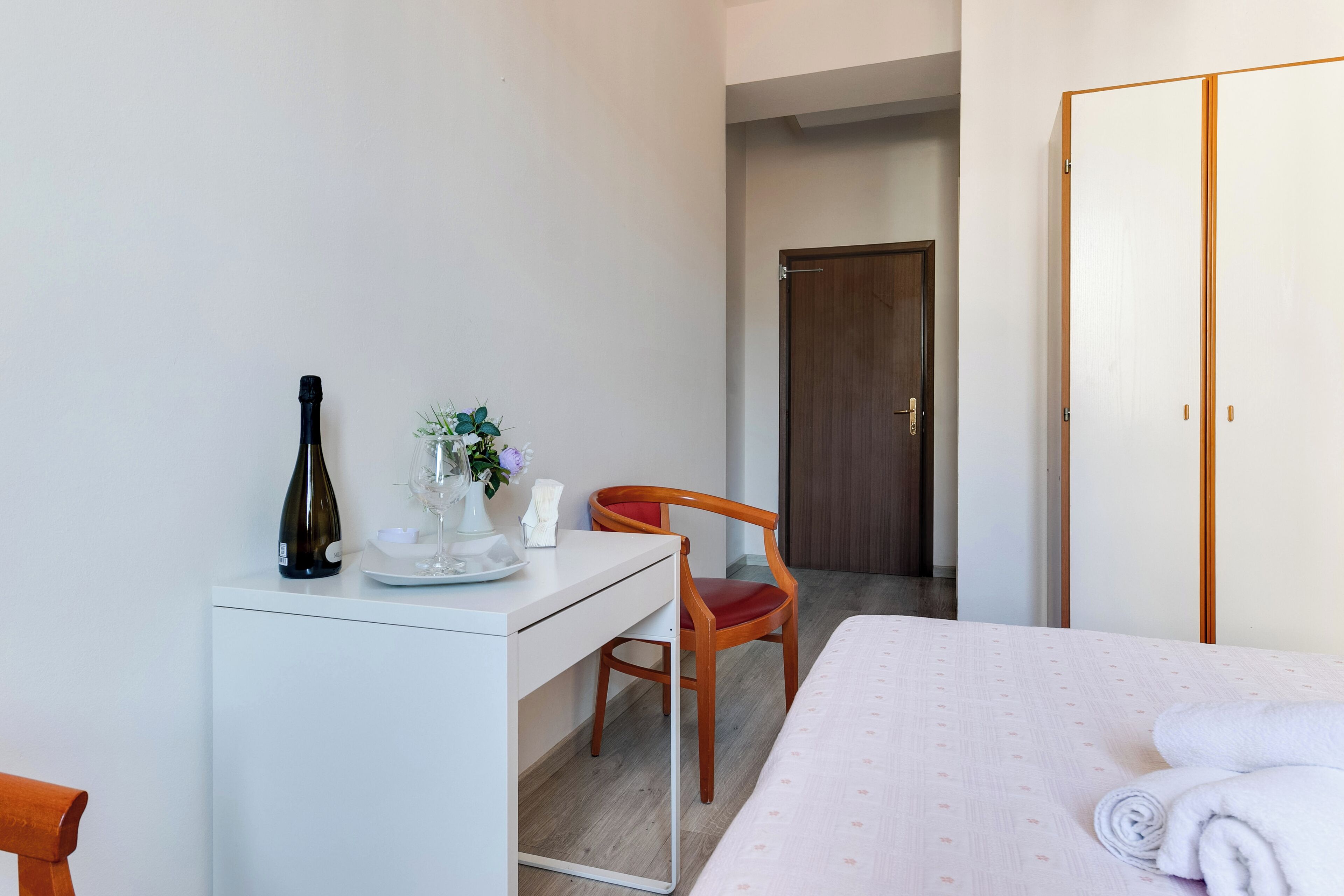 Une chambre d’hôtel comprenant un lit, un bureau avec une chaise, une armoire et une porte.